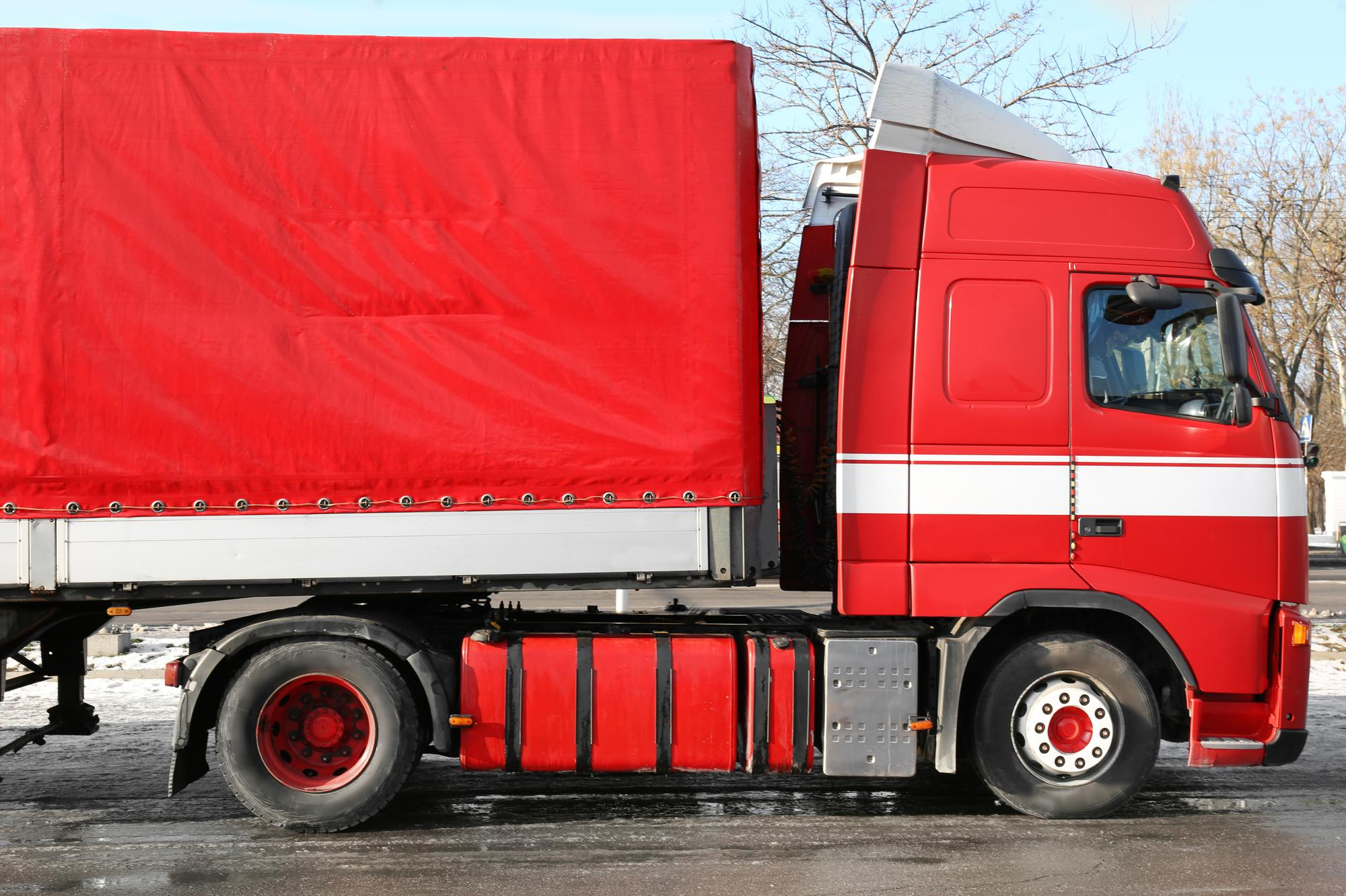 Camion rojo de lona delante